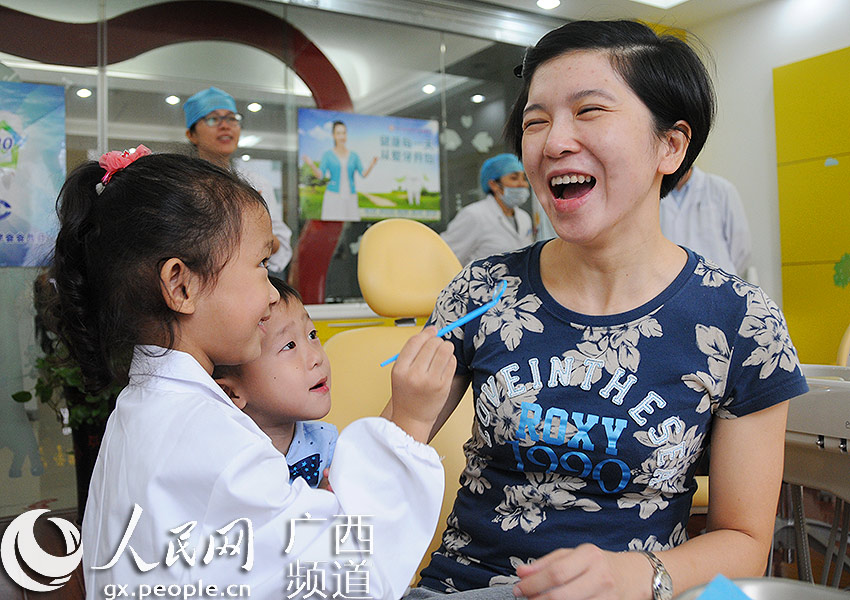 :全国爱牙日 南宁儿童变身小小牙医与父母互