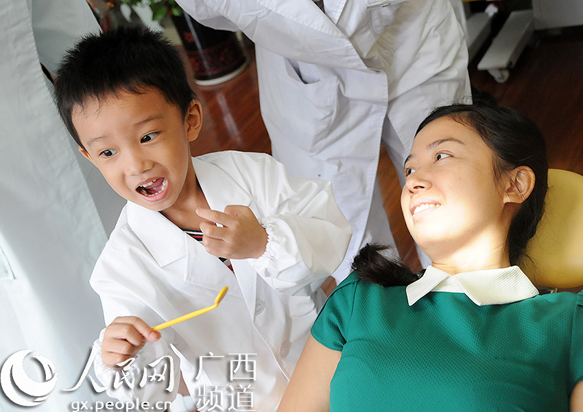 :全国爱牙日 南宁儿童变身小小牙医与父母互