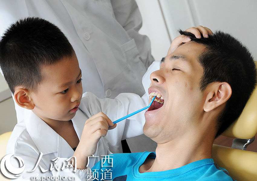 :全国爱牙日 南宁儿童变身小小牙医与父母互