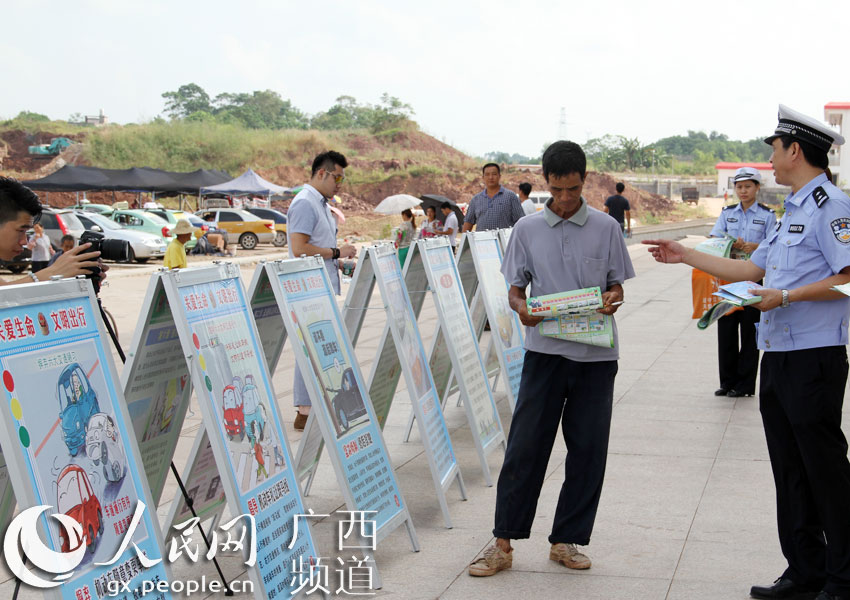 桂平交警与志愿者在高铁站开展国庆交安宣传