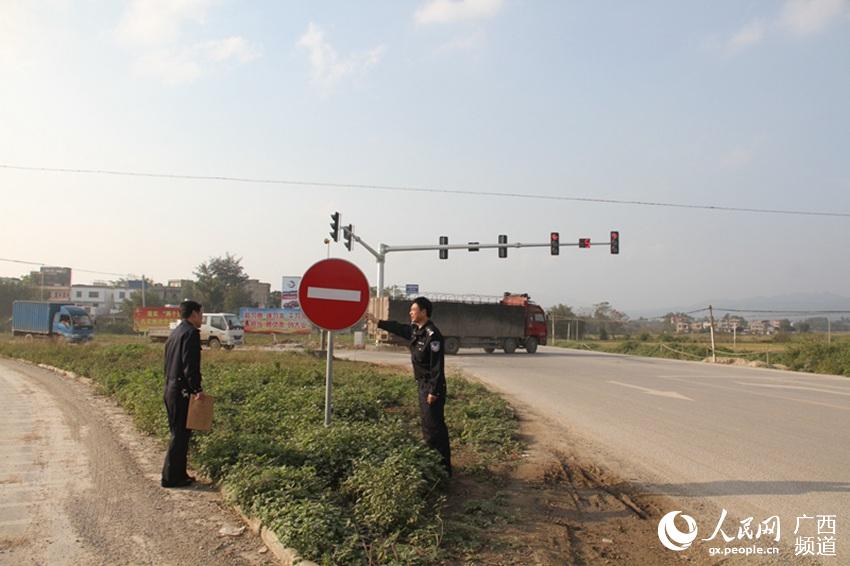 图为桂平交警在蒙圩红绿灯路口检查交通标志设置