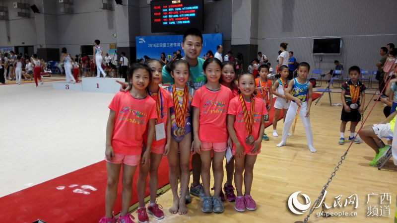 广西体校唐俊威教练(中)与女子体操队员合影(左起:王柳丹,黎雯,韦筱圆