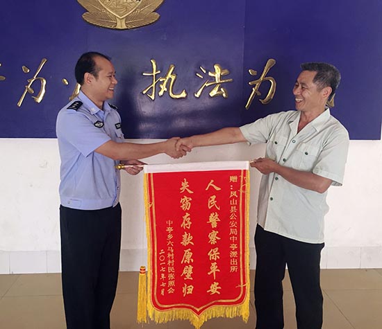 受害群眾將錦旗送到民警手中