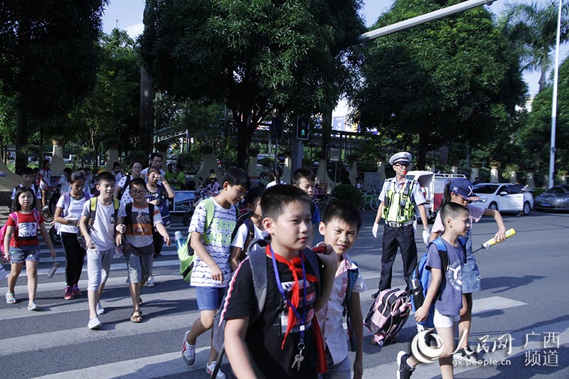 9月1日下午,南宁市琅东小学,交警正在护送放学的小学生.