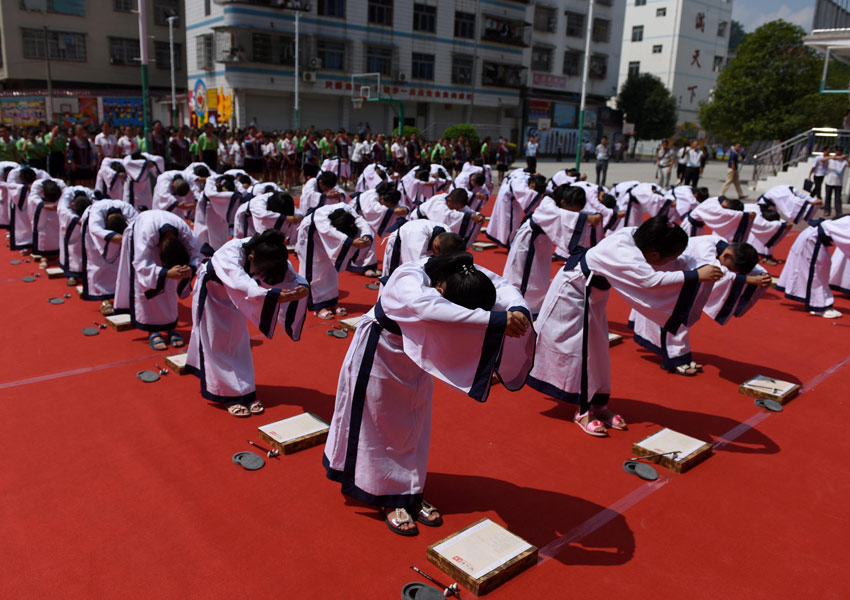 9月15日,学生们在三江侗族自治县古宜镇中心小学开笔礼仪式上行拜师礼