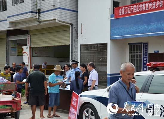 金城江區防范辦在六甲鎮街道上給群眾發放反邪教資料