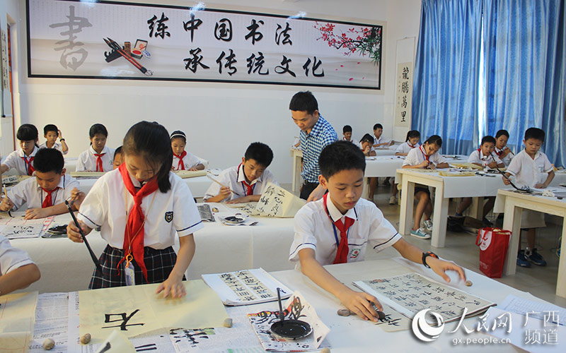 横县横州镇柳明小学学生在书画室练习书法