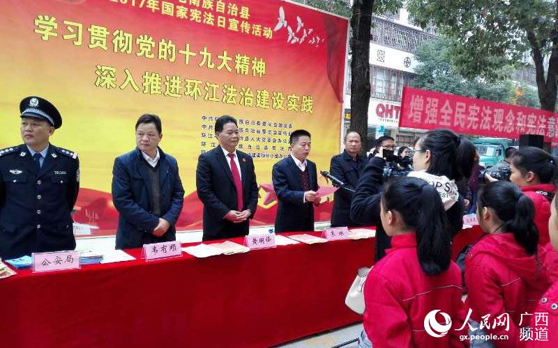 環江縣委常委、政法委書記朱琳（左四）等縣領導帶頭上街開展法治宣傳活動