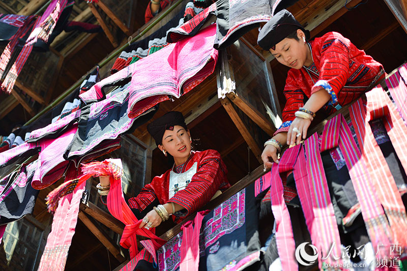 7月18日，在广西龙胜各族自治县龙脊镇大寨村，瑶族同胞在晒花衣花裙。