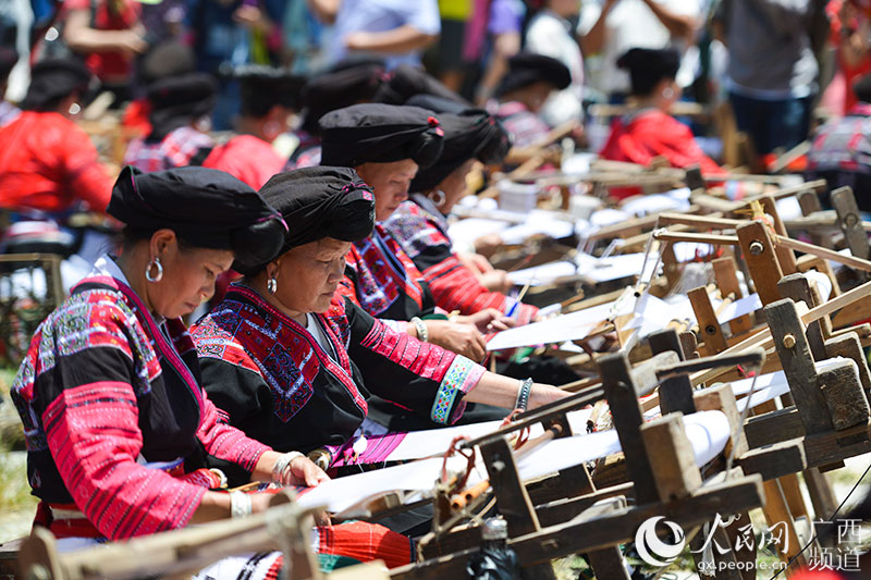 瑶族同胞在展示传统红瑶服饰制作工艺