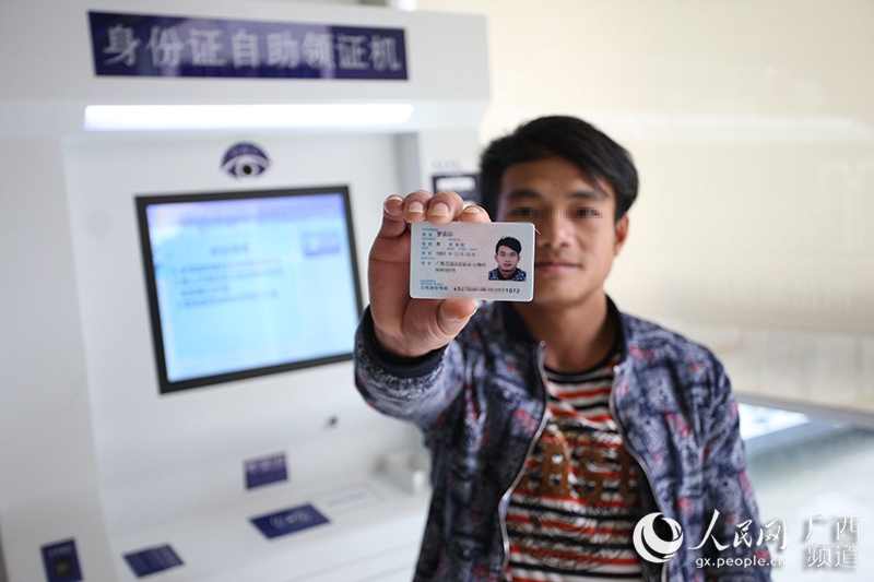 市民通过身份证自助领证机领取新的身份证(耿