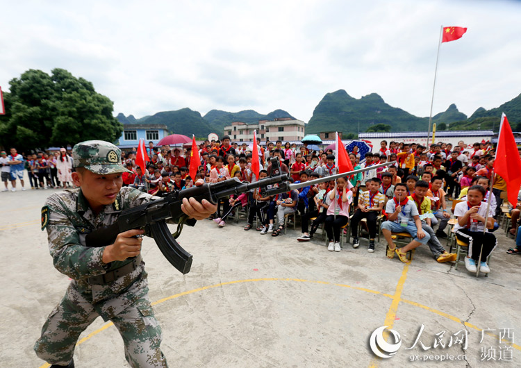 融安县人民武装部战士正在给孩子们传授刺刀操
