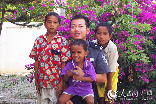 2003年，文龙与东帝汶儿童在一起。广西政法委供图