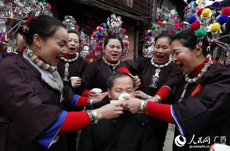 當地群眾在給客人敬酒。吳練勛攝