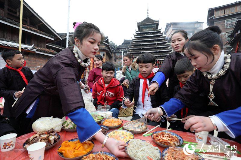 1月18日，在三江侗族自治縣獨峒鎮高定村，幾名侗族女子在鼓樓前擺百家宴。龔普康攝