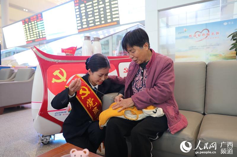 南寧東站“劉三姐”服務台工作人員為旅客縫補物品。南寧東站供圖