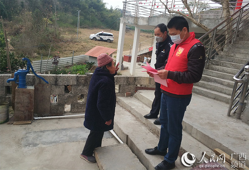 李炳雄正在向群眾發放疫情防控宣傳單。翟明興攝