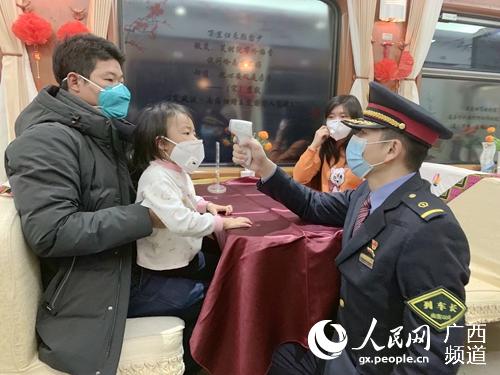 李喜龍為旅客測量體溫。冉慧攝