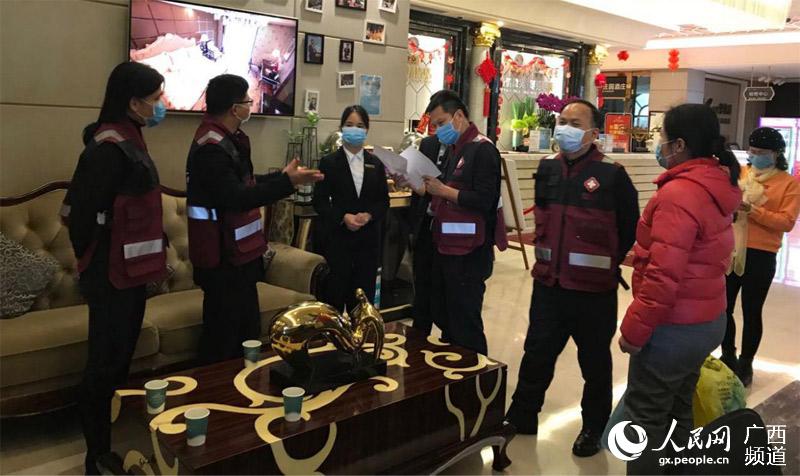 領導小組帶隊到酒店排查與宣傳。北流市疾病預防控制中心供圖