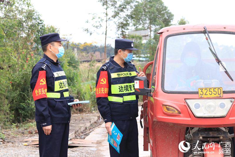 黨員民警向過往群眾發放防疫宣傳手冊。崇左邊境管理支隊寧明邊境管理大隊供圖