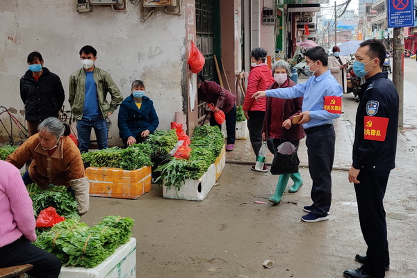 巡邏隊員在蔬菜市場宣傳做好防疫工作。陳煜華攝