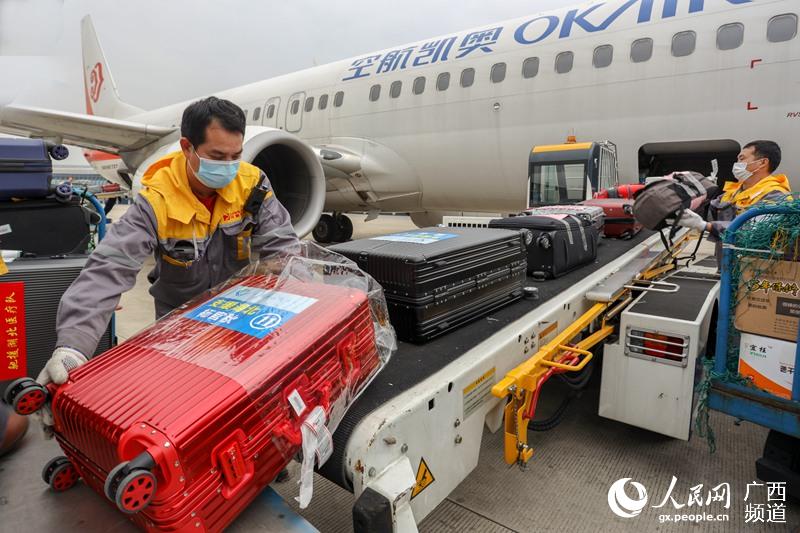 圖為當天下午4時許，南寧吳圩國際機場工作人員正在緊張有序地裝運醫療隊的隨行物資和行李。吳明江攝