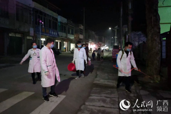 圖為鳳梧衛生院志願者到街道進行消毒工作。李周娜攝
