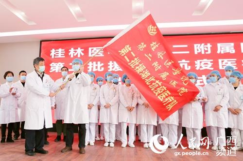 桂林醫學院第二附屬醫院黨委書記宋劍非為醫療隊員們授旗。歐科彤