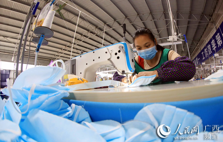 一名女工在扶貧微車間普通民用口罩生產線上作業。譚凱興攝