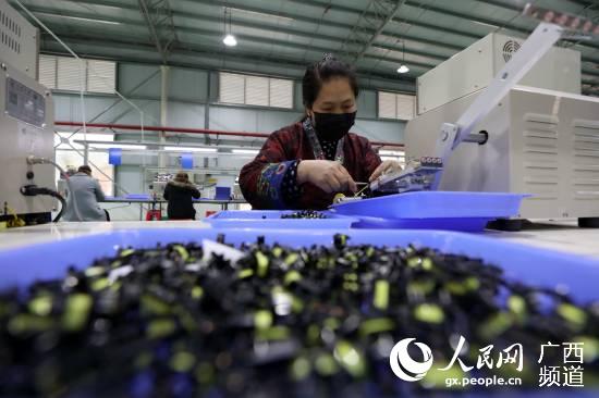 在廣西三江侗族自治縣聚米電子科技有限公司，一名員工在車間內加工零件。龔普康攝