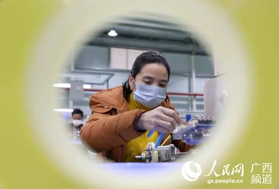 在廣西三江侗族自治縣聚米電子科技有限公司，一名員工在車間內加工零件。龔普康攝