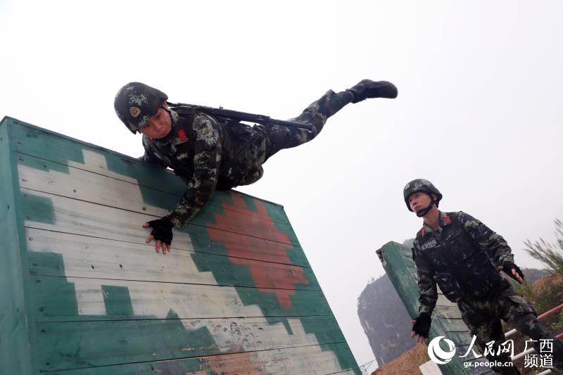  通過200米障礙訓練時，武警官兵快速翻越高板牆。孫立志攝
