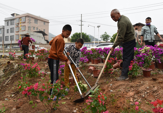 村民群眾帶領小學生一起參加植樹種花活動。諸葛蔓華攝