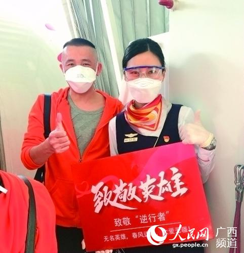 在飛機上，空姐與桂林醫學院第二附屬醫院醫療隊員合影，為醫療隊員點贊。桂林醫學院供圖