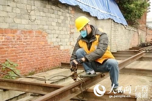 石才壯在裝運鋼軌。覃文願攝