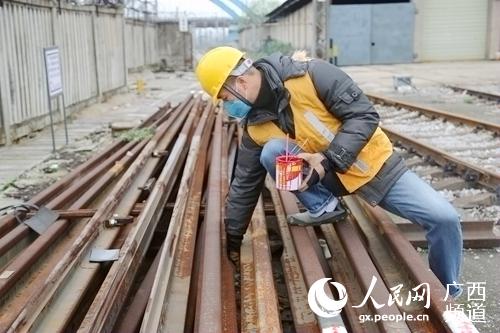 石才壯在在檢查鋼軌型號。覃文願攝