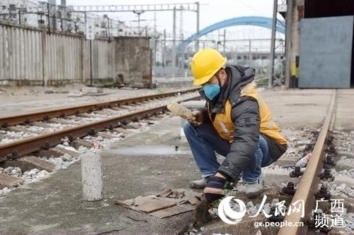 石才壯對軌料場垃圾進行清理。覃文願攝