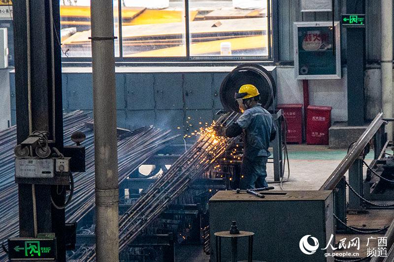 在廣西電力線路器材廠有限責任公司的生產車間內，工人正在焊接鋼筋。吳明江攝