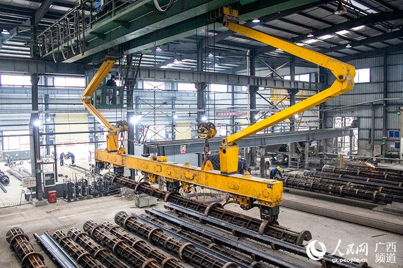 在廣西電力線路器材廠有限責任公司的生產車間內，機械臂正在吊裝模具。吳明江攝