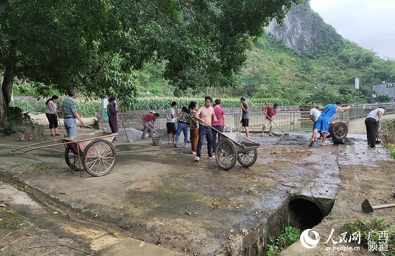 村民們在修補硬化被損壞的公共場所。韋泰 攝