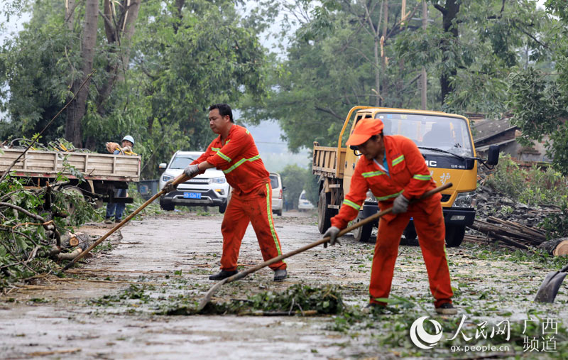 公路搶修人員在清理道路上大風吹倒的樹木。譚凱興攝