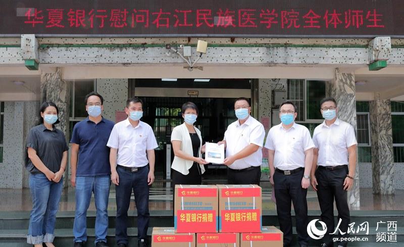 華夏銀行南寧分行副行長陸海東（右三）代表華夏銀行向右江民族醫學院捐贈2萬個醫用外科口罩。楊揚攝