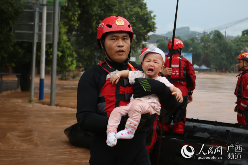 消防救援人員懷抱著幼童轉移到安全地帶。桂林市消防救援支隊供圖