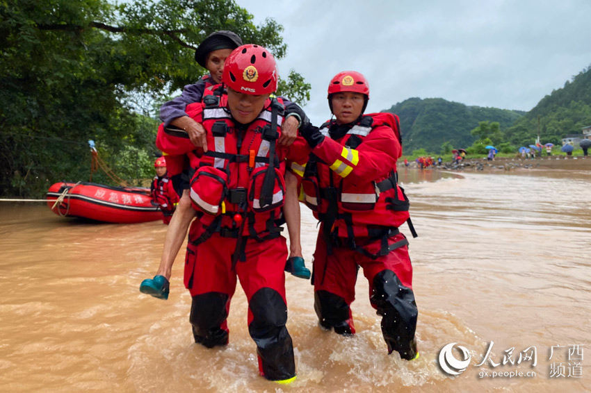在下信村，消防救援人員背著老人過河。張月海攝