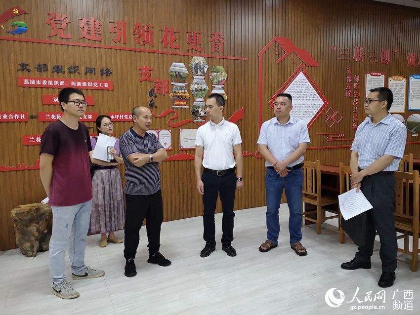 在蘭花協會黨支部聽取黨支部書記介紹“三聯三創”做法。荔浦市兩新組織黨工委供圖