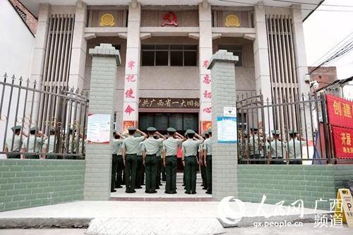 武警官兵在中共廣西省一大舊址前重溫入黨誓詞。孫躍攝