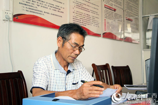 正在村委整理文件的廖振江。王孝強攝