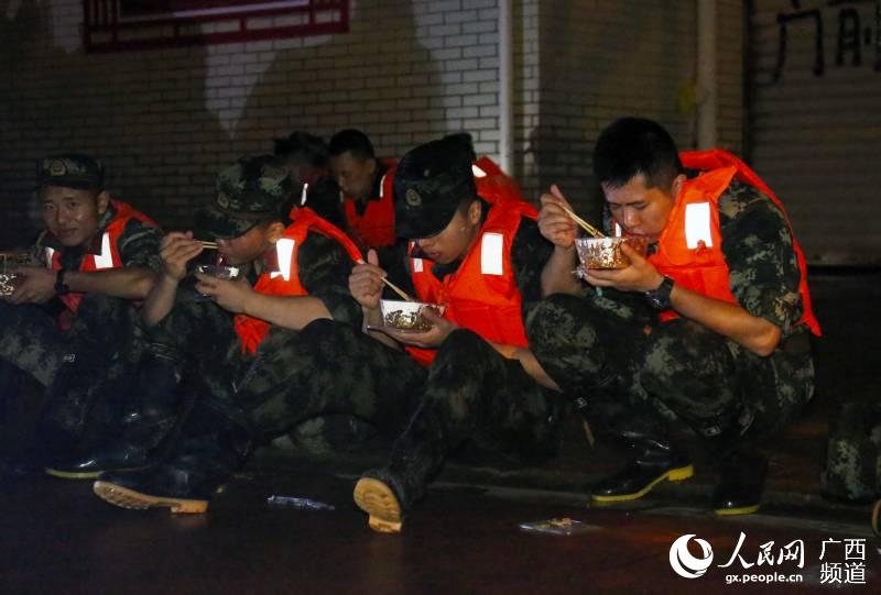 7月13日凌晨，武警柳州支隊官兵抽空補充飲食。喬延攝
