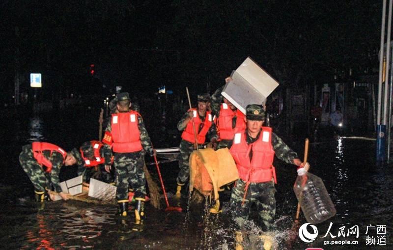 7月12日晚，武警柳州支隊官兵正在清運垃圾。岑朗攝