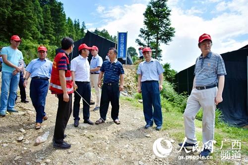 柳州機車車輛公司領導與良隴村干部實地勘察商討道路硬化拓寬方案。韋洲攝